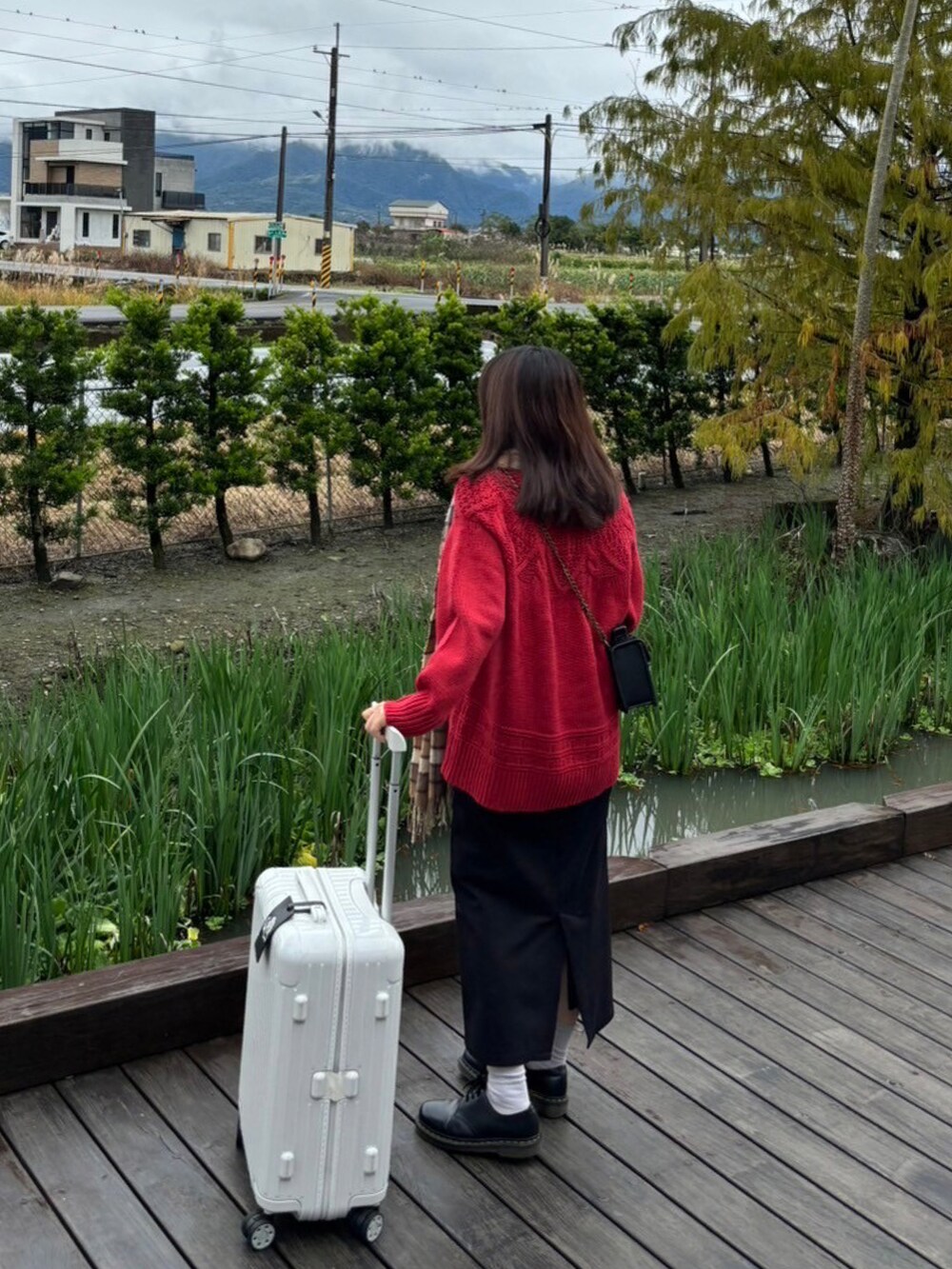 ブラック系のスカート、レッド系のニット/セーター、ブラック系のローファーを着用したレディースの秋コーディネートの3枚目の写真