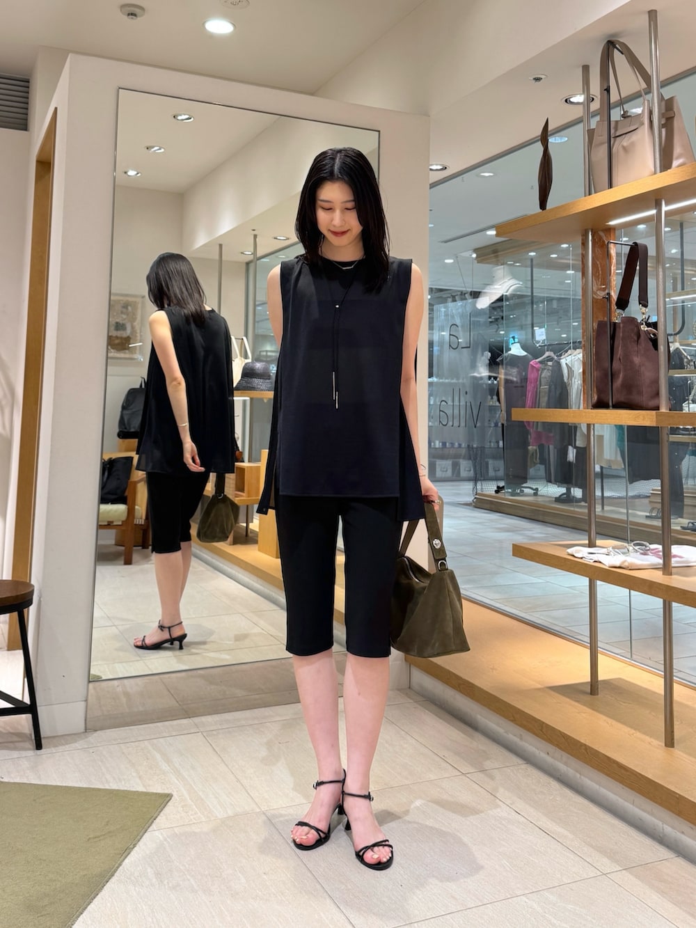ブラック系のその他パンツ、グリーン系のトートバッグ、ブラック系のTシャツ/カットソーを着用したレディースの夏コーディネートの2枚目の写真