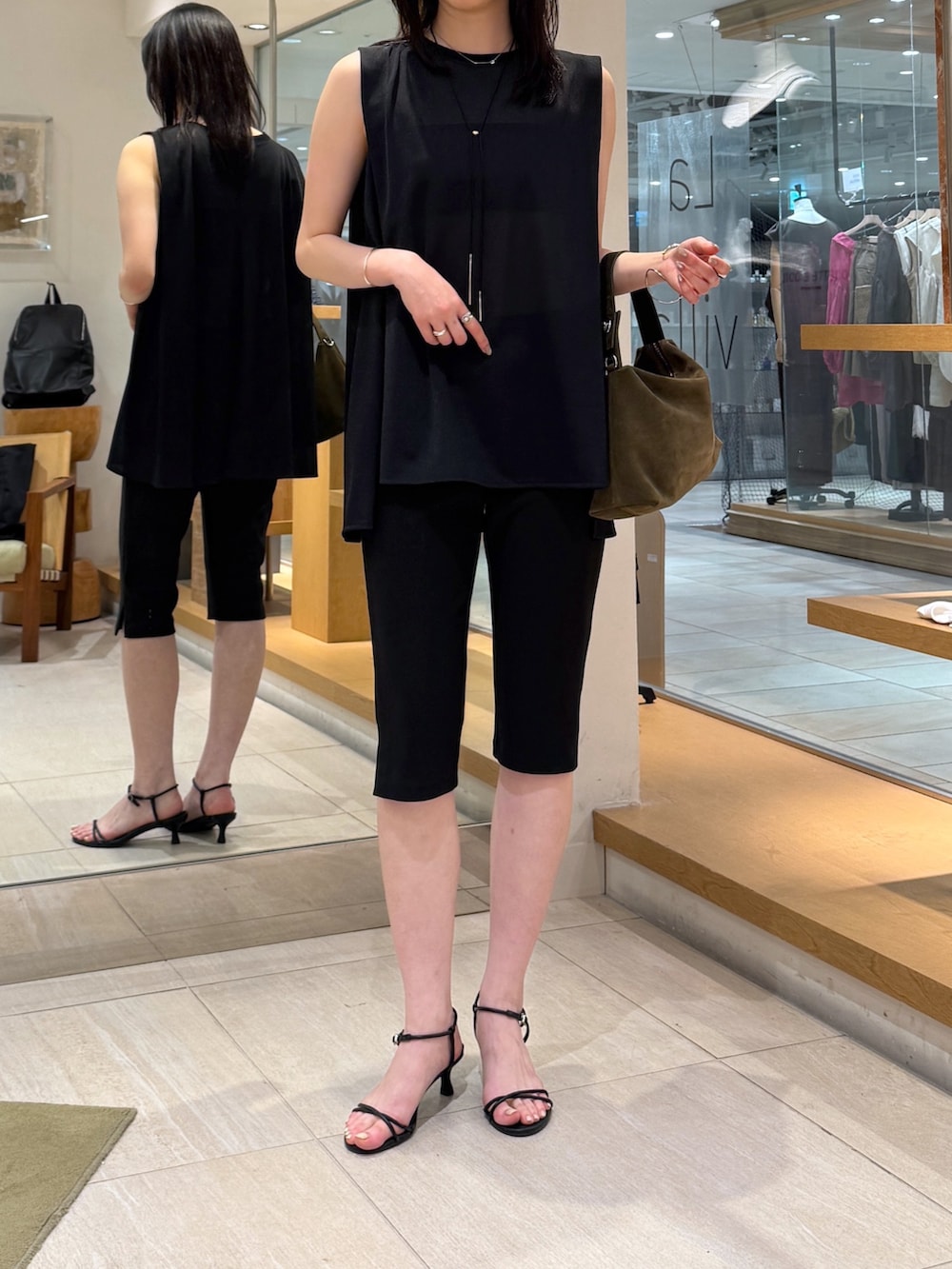 ブラック系のその他パンツ、グリーン系のトートバッグ、ブラック系のTシャツ/カットソーを着用したレディースの夏コーディネートの3枚目の写真