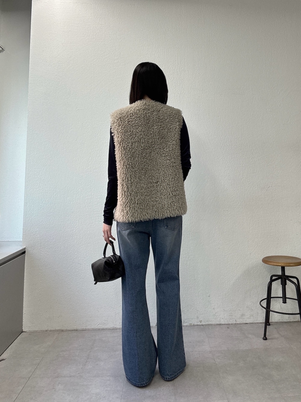 ブルー系のデニムパンツ、ブラウン系のその他シューズ、ベージュ系のベストを着用したレディースの夏コーディネートの3枚目の写真