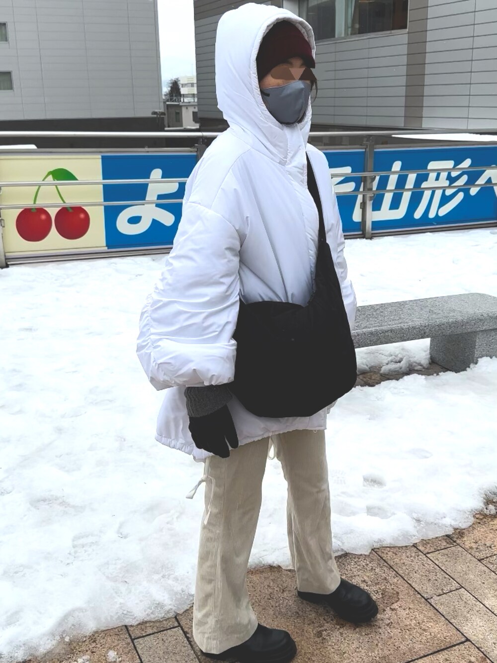 ブラック系のショルダーバッグ、ホワイト系のブルゾン、ホワイト系のパンツを着用したレディースの冬コーディネートの2枚目の写真