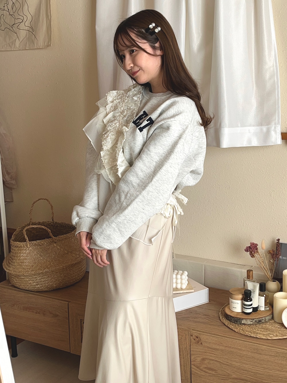 ブルー系のスウェット、ベージュ系のスニーカー、ホワイト系のスカートを着用したレディースの秋コーディネートの2枚目の写真