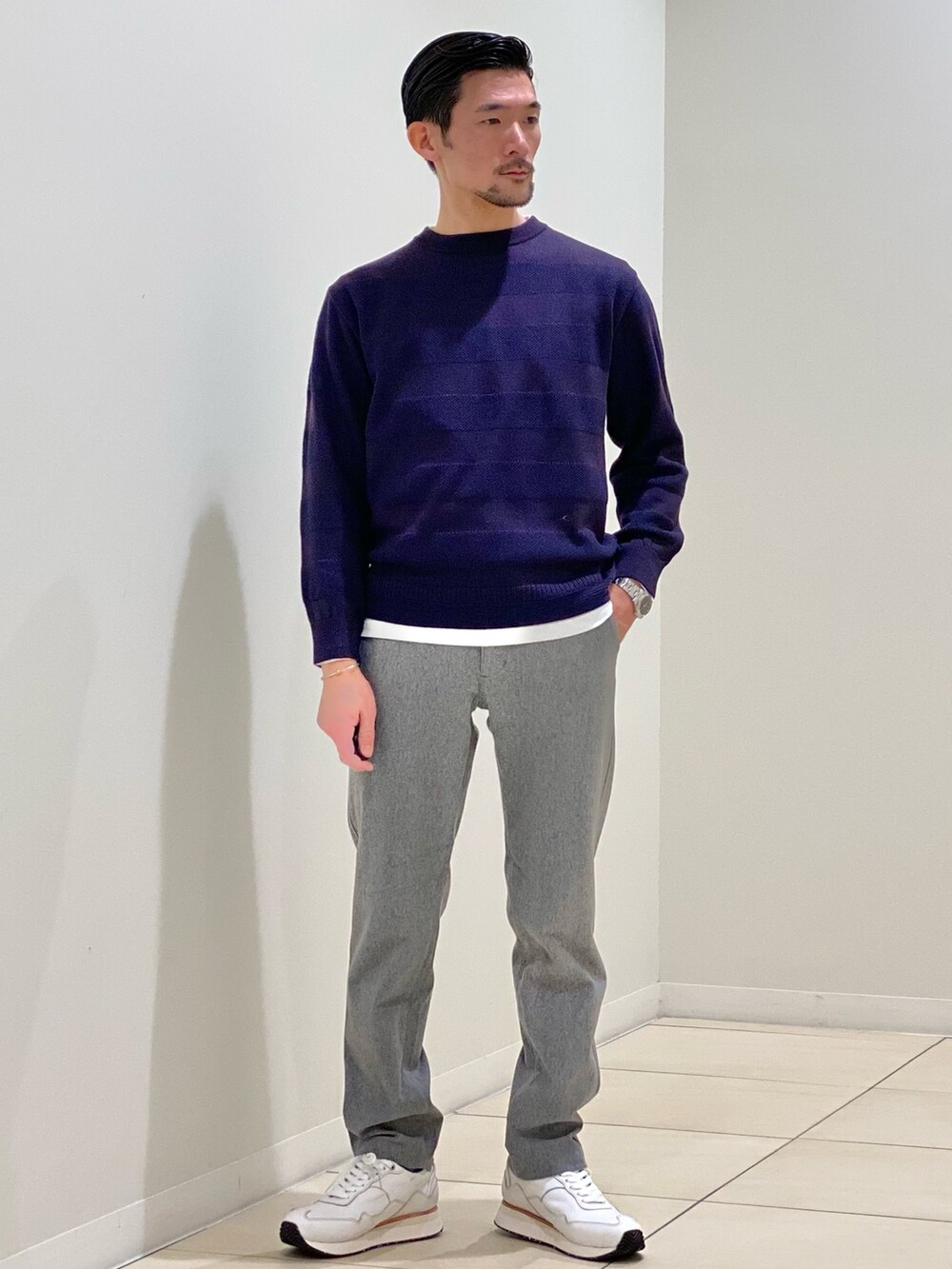 パープル系のニット/セーター、グレー系のその他パンツ、ホワイト系のスニーカーを着用したメンズの秋コーディネートの8枚目の写真