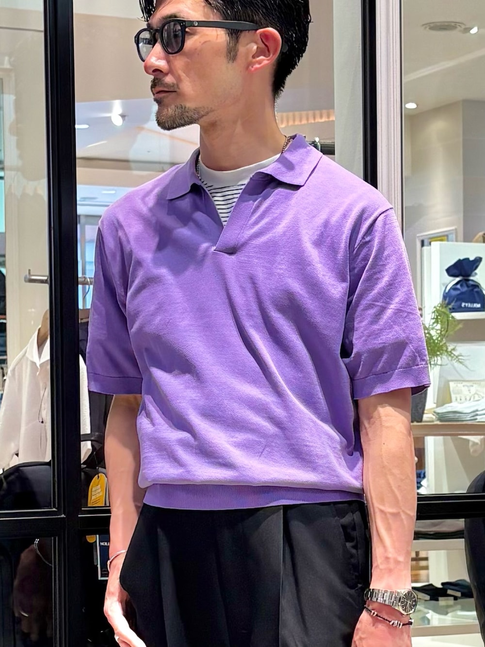 パープル系のポロシャツ、ブラック系のトートバッグ、ブラック系のその他パンツを着用したメンズの夏コーディネートの9枚目の写真