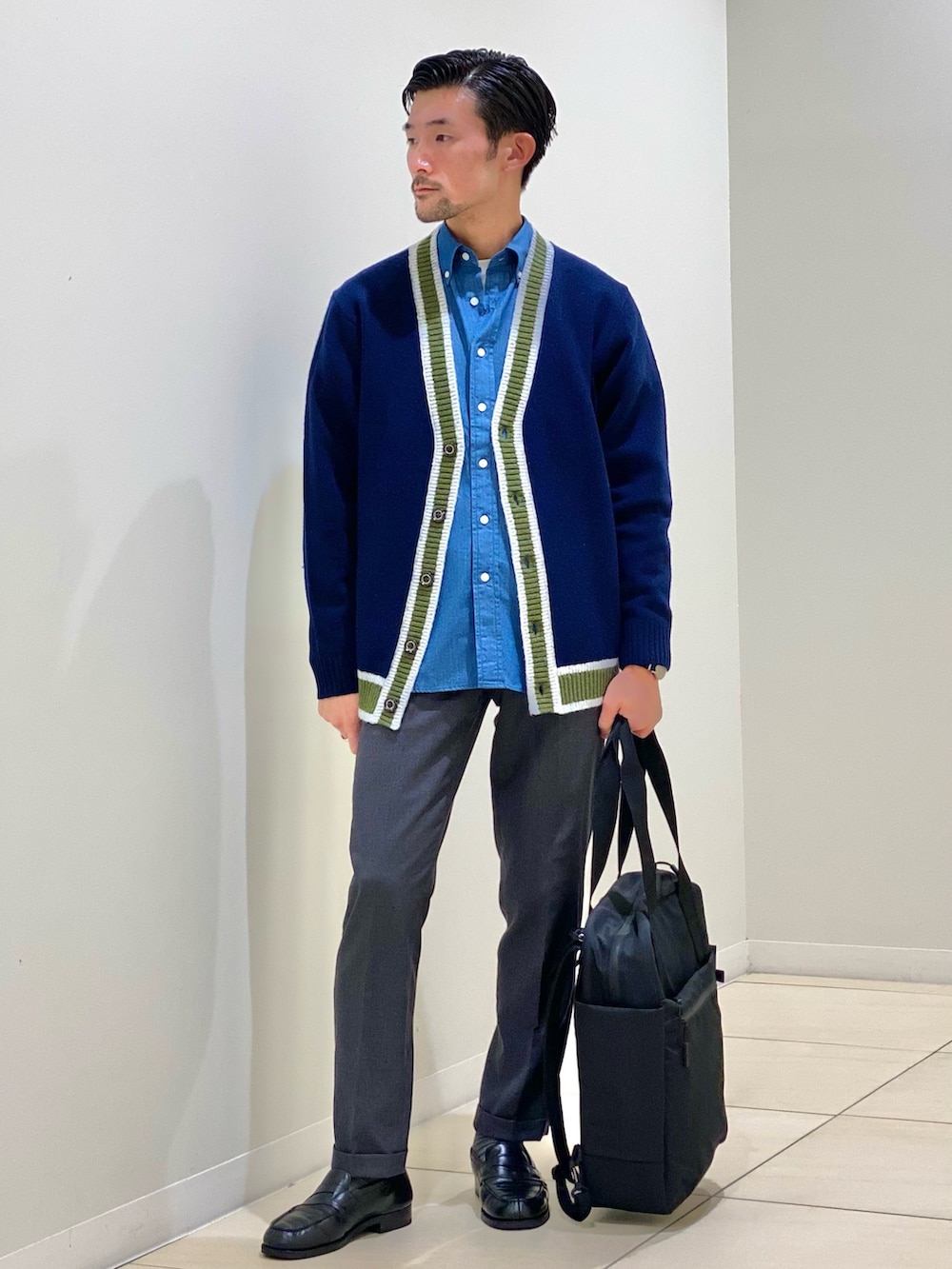 ブラック系のトートバッグ、ブルー系のカーディガン/ボレロ、ブルー系のシャツ/ブラウスを着用したメンズの秋コーディネートの2枚目の写真