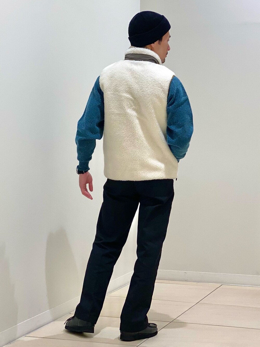 ホワイト系のダウンベスト、グリーン系のニット/セーター、グリーン系のマフラーを着用したメンズの冬コーディネートの4枚目の写真