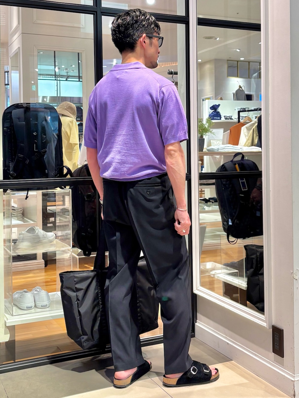 パープル系のポロシャツ、ブラック系のトートバッグ、ブラック系のその他パンツを着用したメンズの夏コーディネートの5枚目の写真