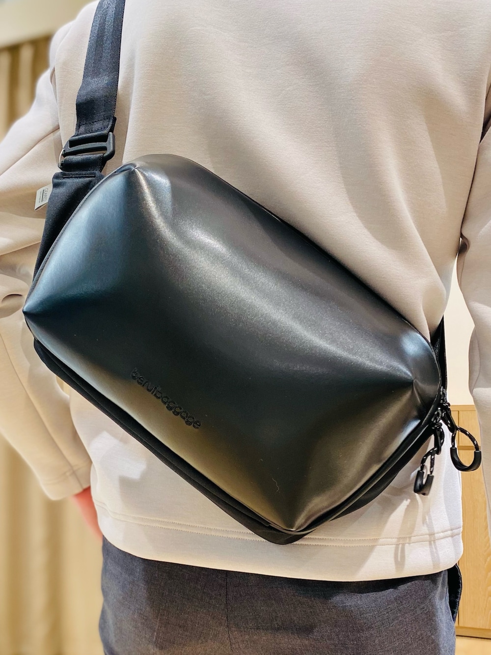 ベージュ系のブルゾン、ブラック系のボディバッグ/ウエストポーチ、ブラウン系のローファーを着用したメンズの冬コーディネートの6枚目の写真