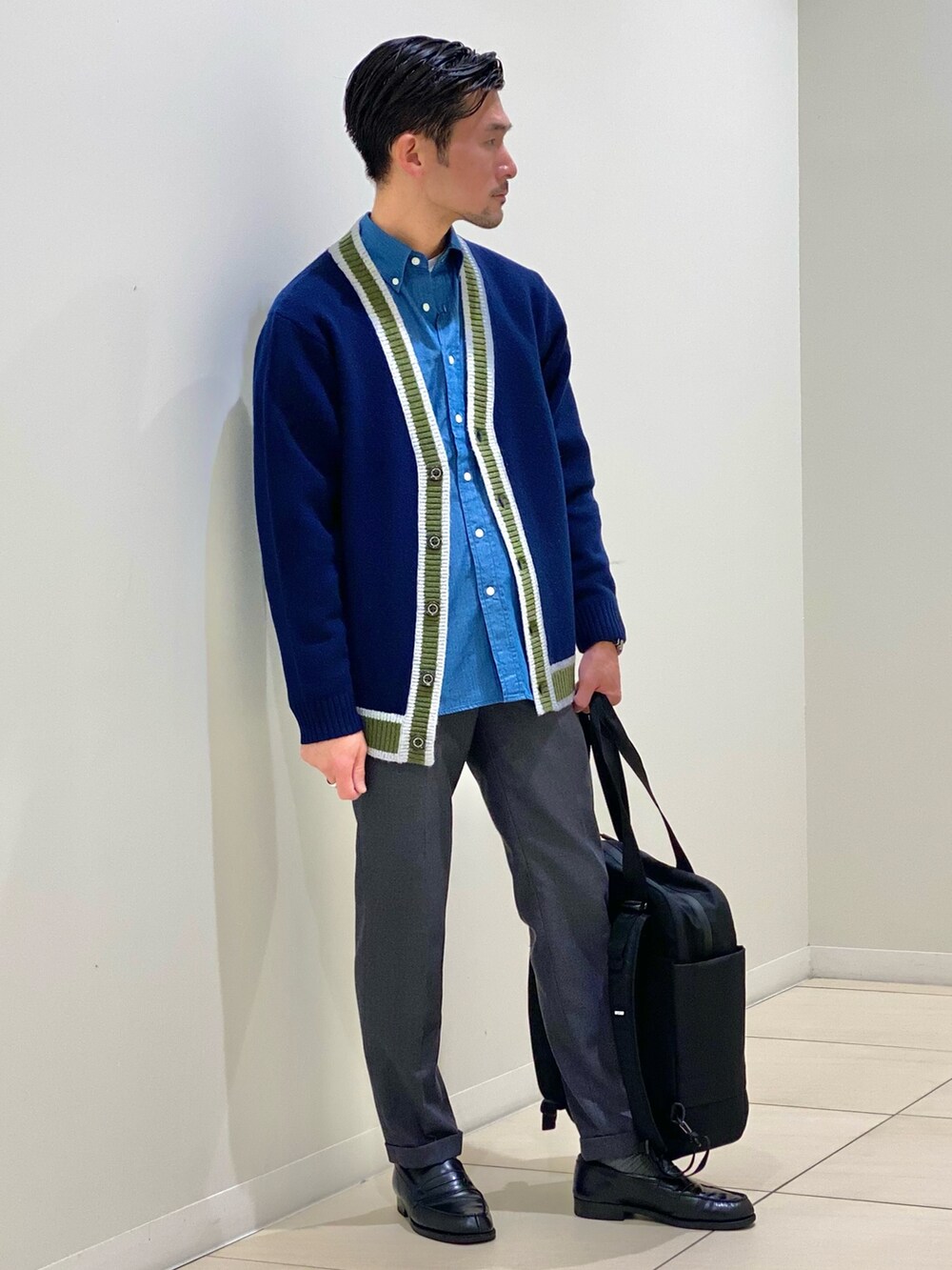 ブラック系のトートバッグ、ブルー系のカーディガン/ボレロ、ブルー系のシャツ/ブラウスを着用したメンズの秋コーディネートの5枚目の写真