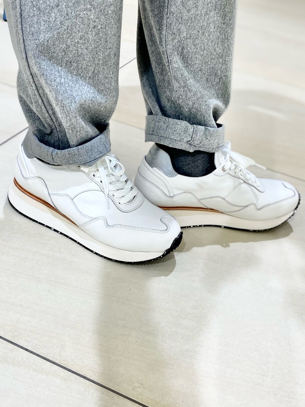 パープル系のニット/セーター、グレー系のその他パンツ、ホワイト系のスニーカーを着用したメンズの秋コーディネートの10枚目の写真