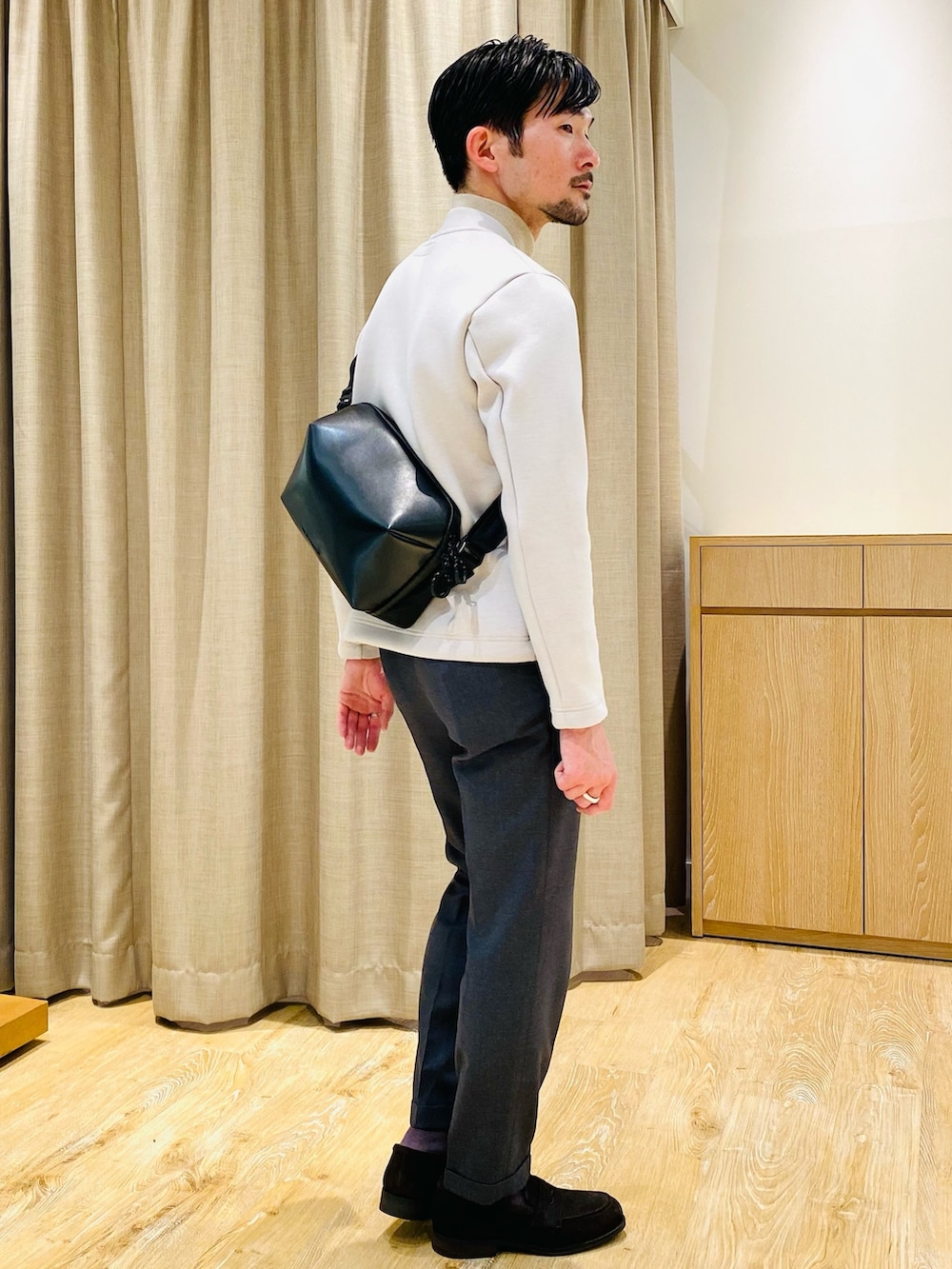 ベージュ系のブルゾン、ブラック系のボディバッグ/ウエストポーチ、ブラウン系のローファーを着用したメンズの冬コーディネートの4枚目の写真