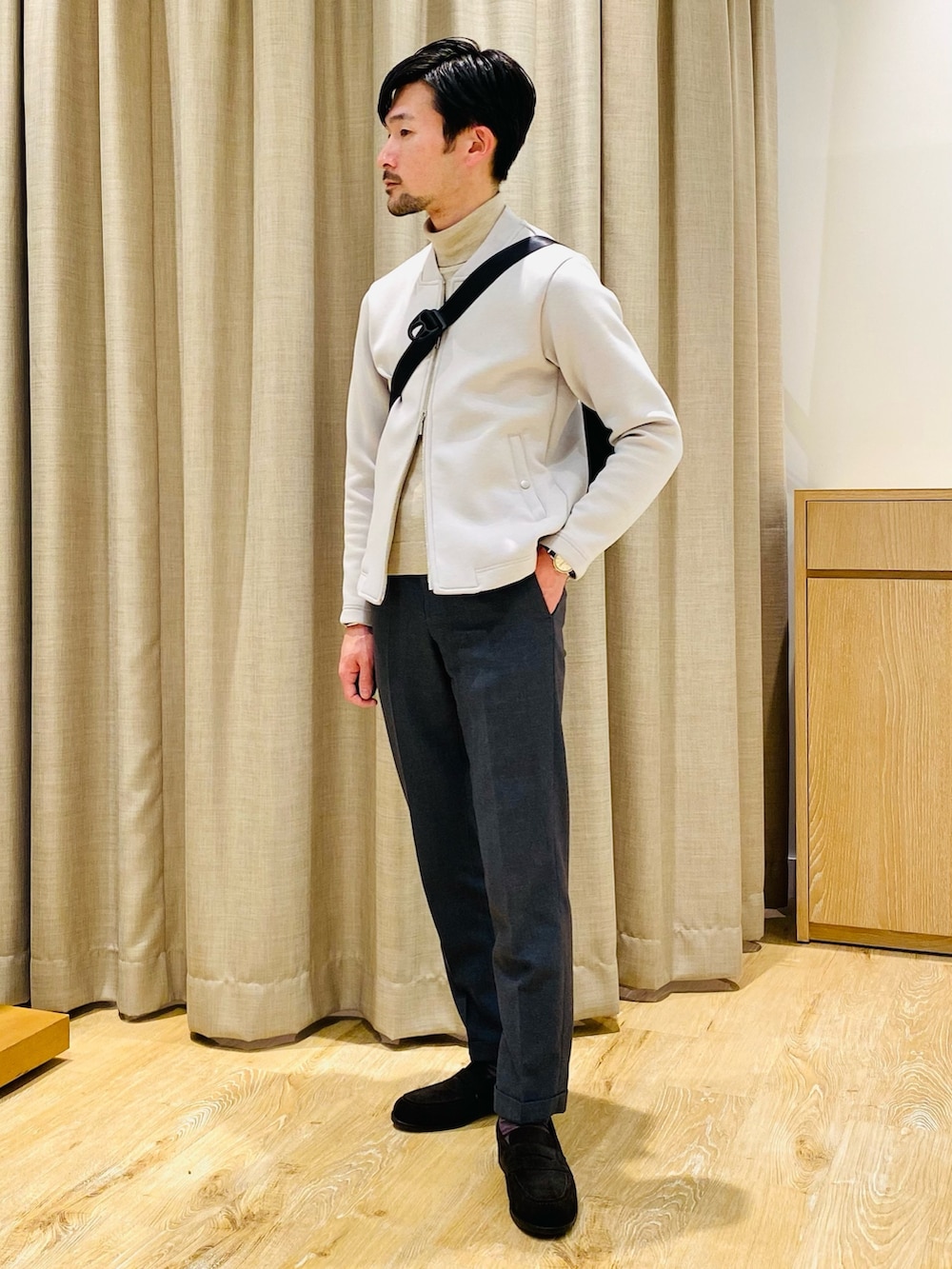 ベージュ系のブルゾン、ブラック系のボディバッグ/ウエストポーチ、ブラウン系のローファーを着用したメンズの冬コーディネートの2枚目の写真