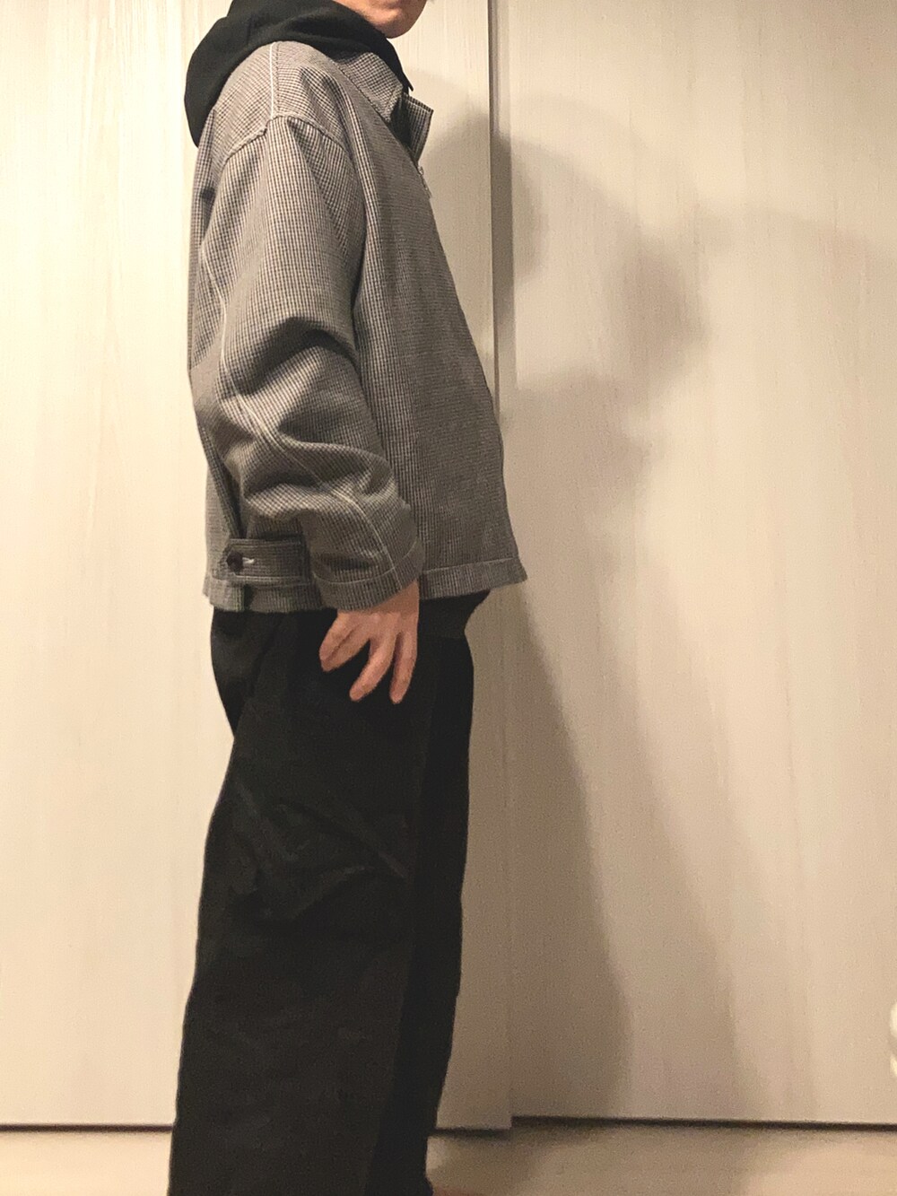 グレー系のブルゾン、ブラック系のパーカーを着用したメンズの冬コーディネートの3枚目の写真