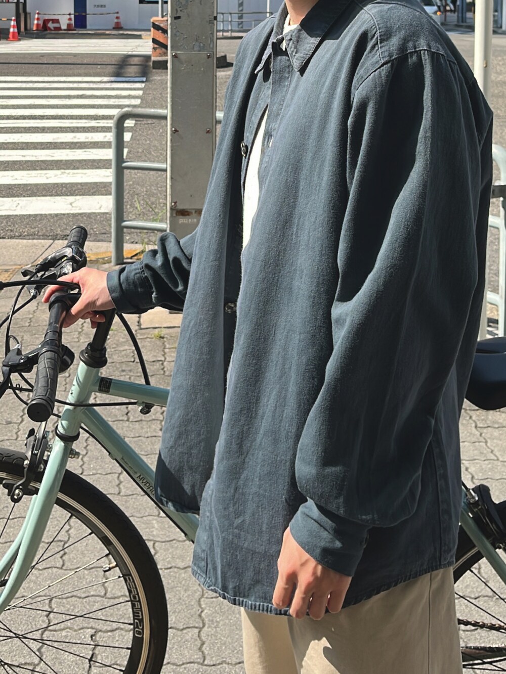 グリーン系のシャツ/ブラウス、ベージュ系のスラックス、ブラック系のローファーを着用したメンズの春コーディネートの2枚目の写真