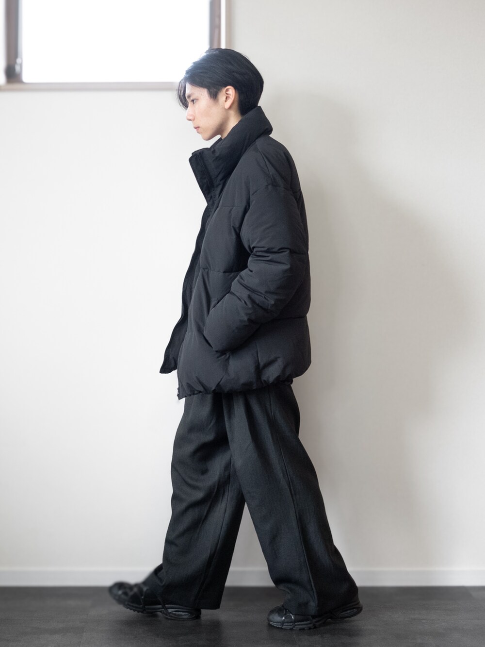 グレー系のその他パンツ、ブラック系のスニーカー、ホワイト系のTシャツ/カットソーを着用したメンズの冬コーディネートの3枚目の写真