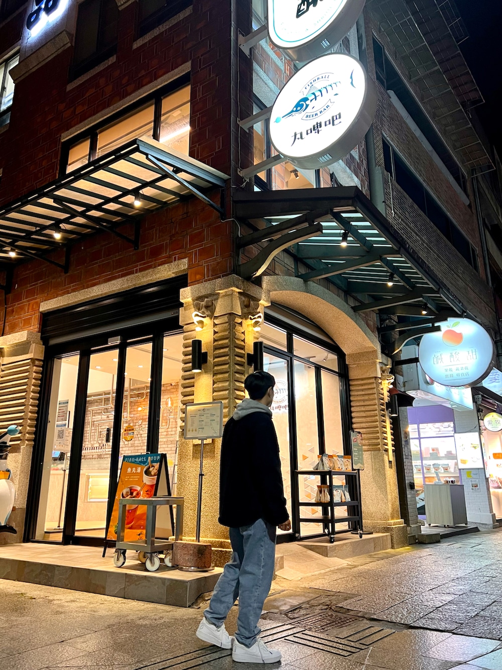 グレー系のパーカー、ブラック系のシャツ/ブラウス、ホワイト系のスニーカーを着用したレディースの春コーディネートの2枚目の写真