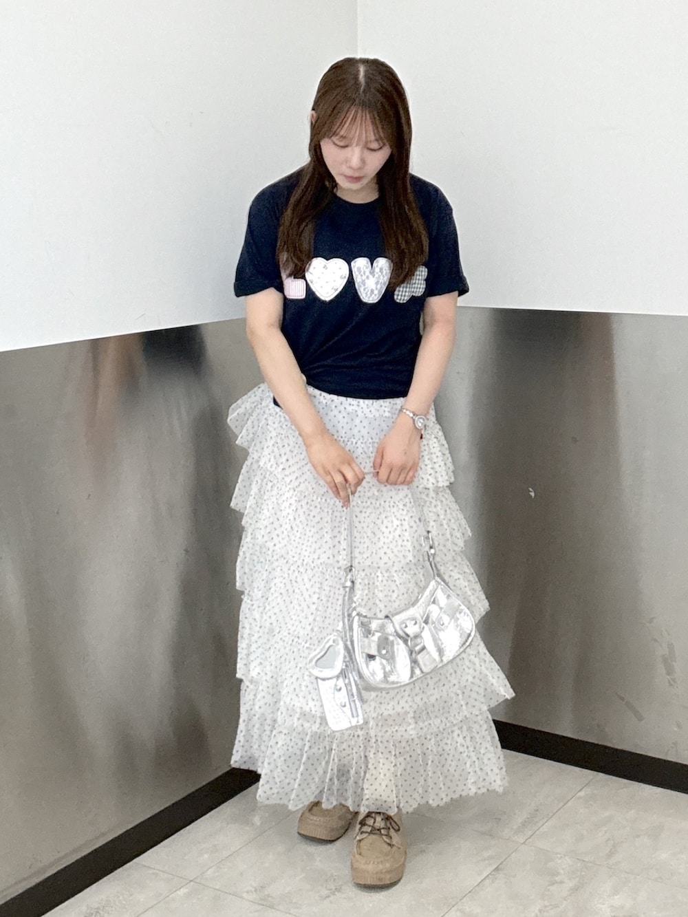 ブルー系のTシャツ/カットソー、ホワイト系のスカート、シルバー系のトートバッグを着用したレディースの夏コーディネートの2枚目の写真