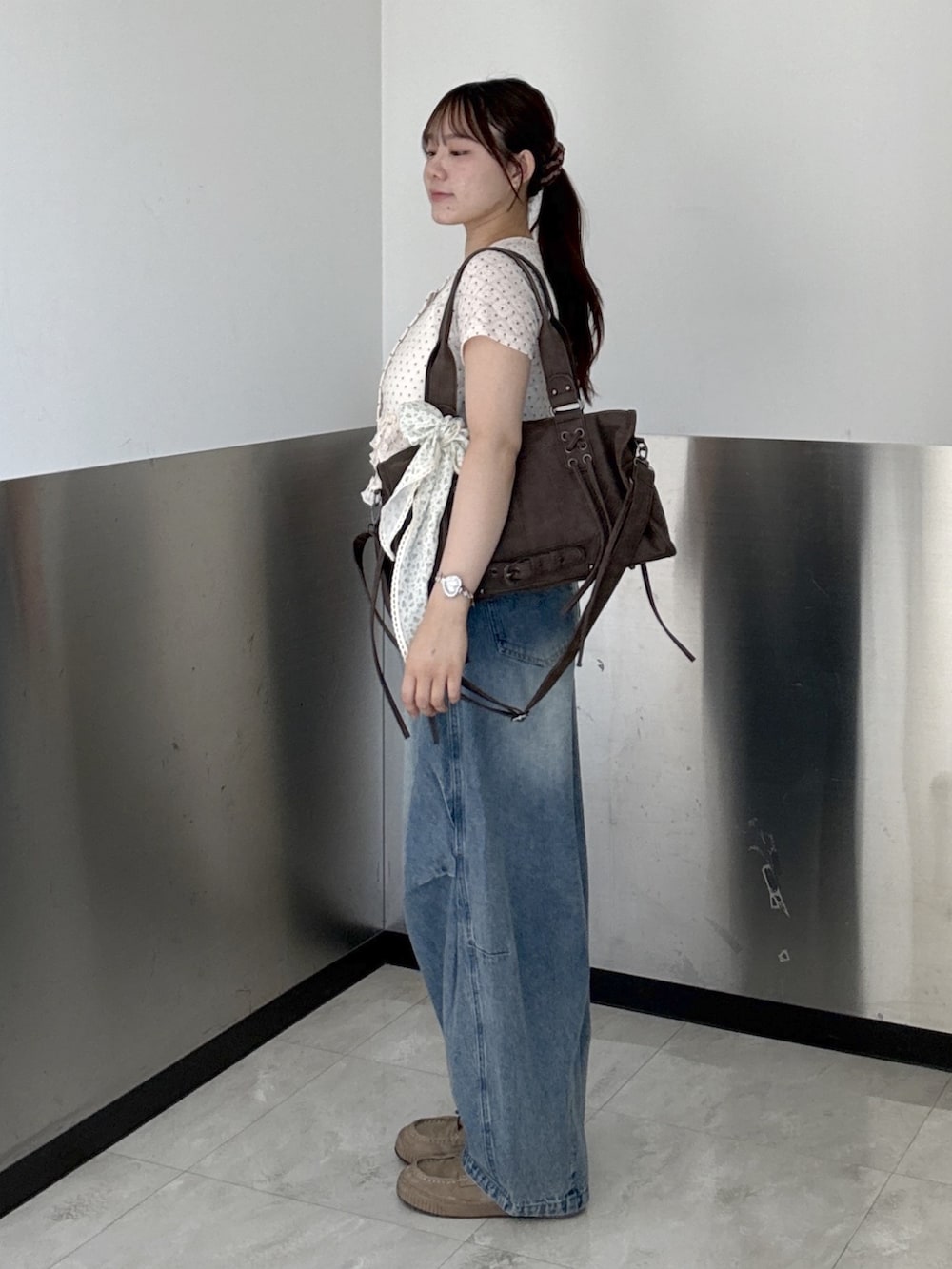 ピンク系のTシャツ/カットソー、ブルー系のデニムパンツ、ブラウン系のボストンバッグを着用したレディースの夏コーディネートの3枚目の写真