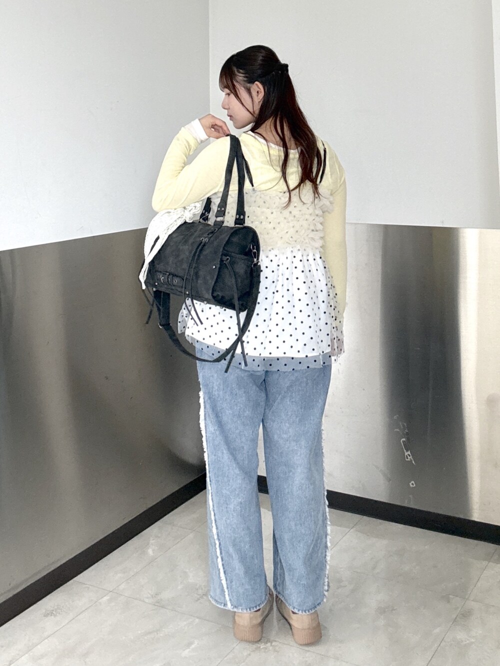 ブラック系のボストンバッグ、ブルー系のデニムパンツ、ホワイト系のシャツ/ブラウスを着用したレディースの夏コーディネートの3枚目の写真