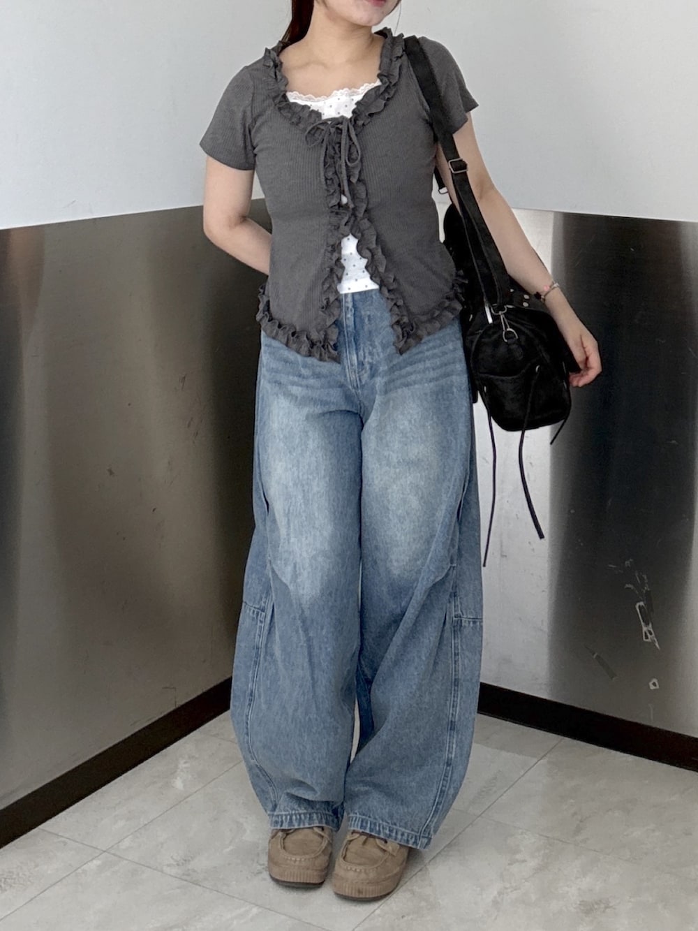 ブルー系のデニムパンツ、グレー系のTシャツ/カットソー、ブラック系のボストンバッグを着用したレディースの夏コーディネートの2枚目の写真