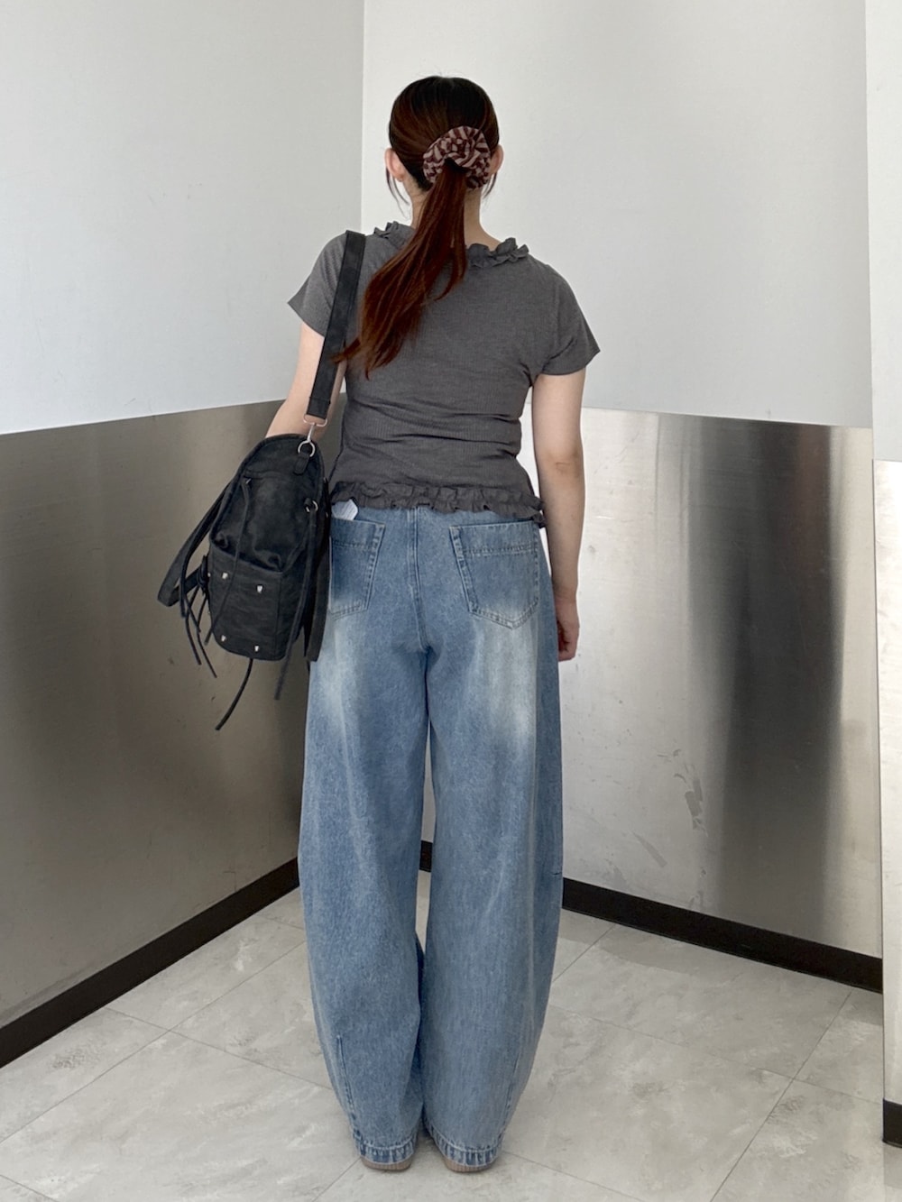 ブルー系のデニムパンツ、グレー系のTシャツ/カットソー、ブラック系のボストンバッグを着用したレディースの夏コーディネートの4枚目の写真