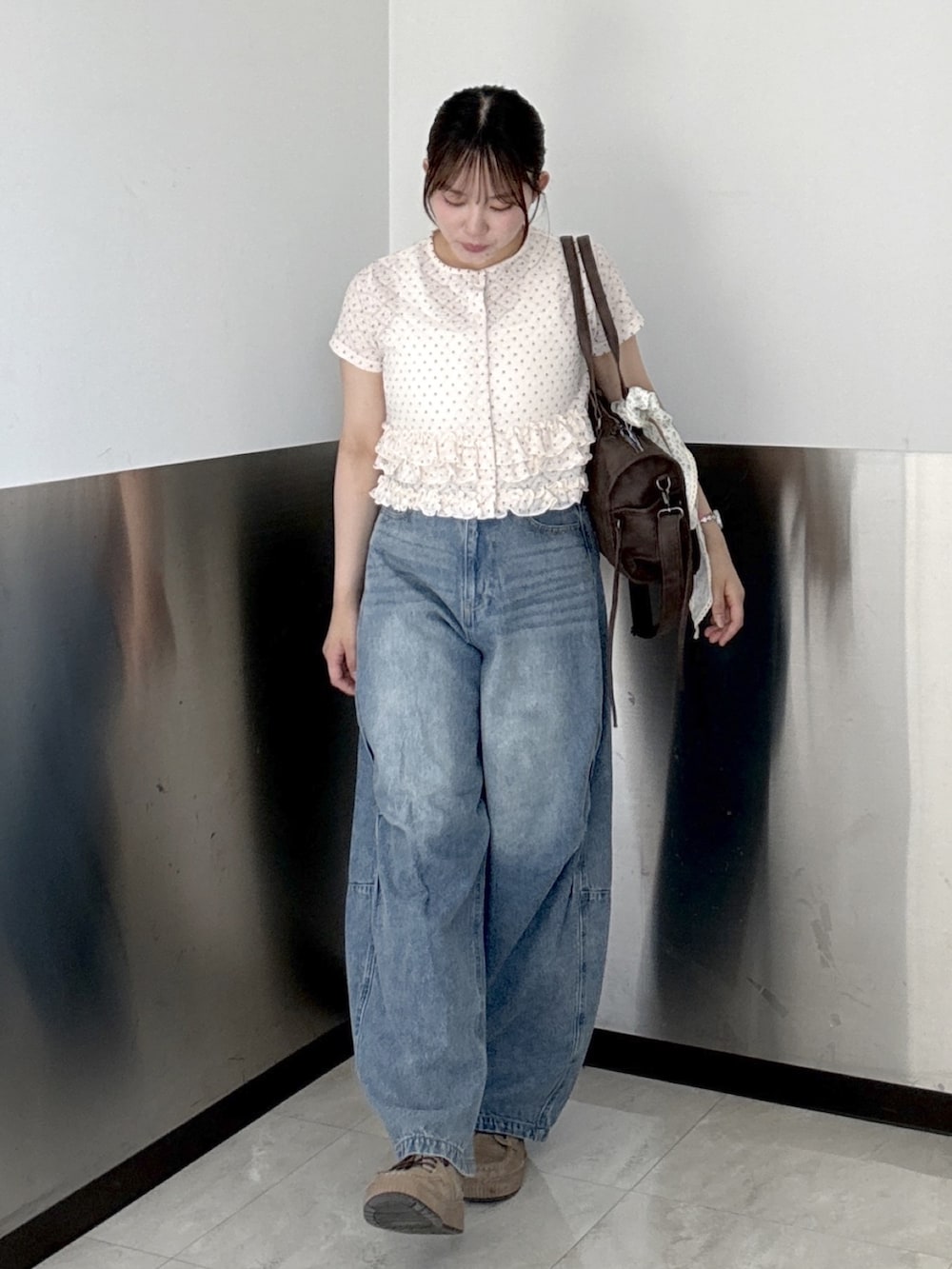 ピンク系のTシャツ/カットソー、ブルー系のデニムパンツ、ブラウン系のボストンバッグを着用したレディースの夏コーディネートの2枚目の写真