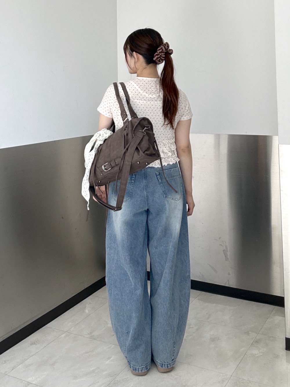 ピンク系のTシャツ/カットソー、ブルー系のデニムパンツ、ブラウン系のボストンバッグを着用したレディースの夏コーディネートの4枚目の写真