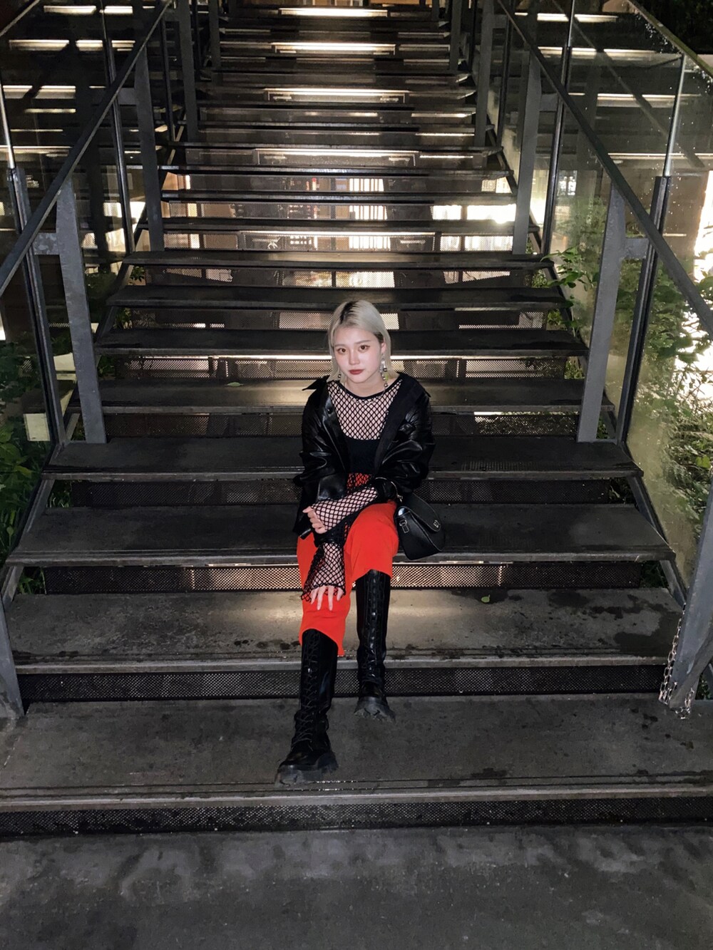 ブラック系のTシャツ/カットソー、レッド系のスラックスを着用したレディースの春コーディネートの2枚目の写真