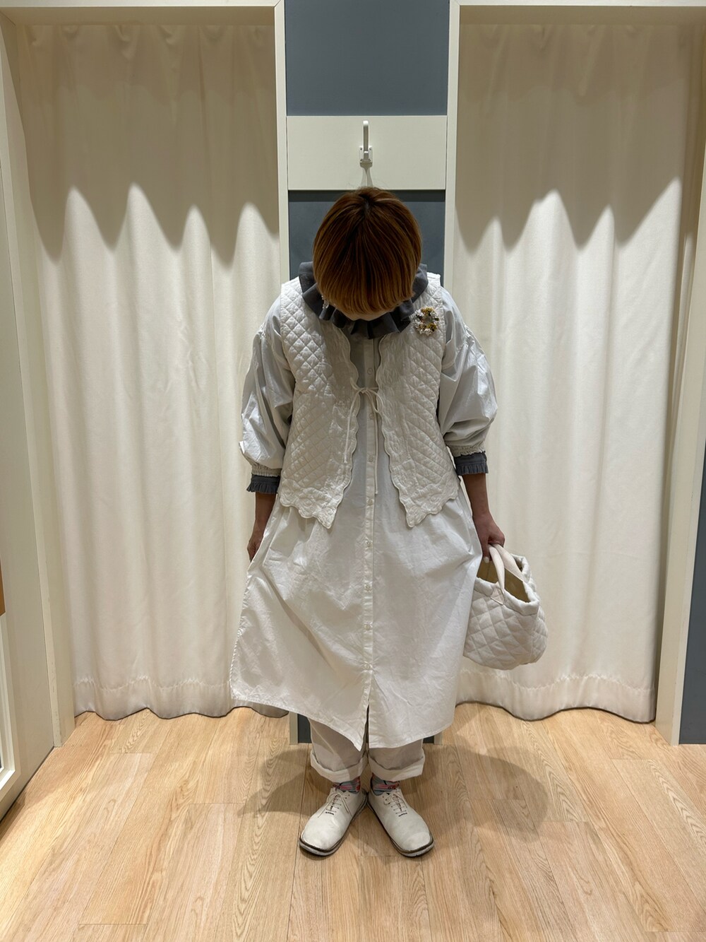 ブラック系のシャツ/ブラウス、ホワイト系のベスト、ホワイト系のシャツワンピースを着用したレディースの春コーディネートの2枚目の写真