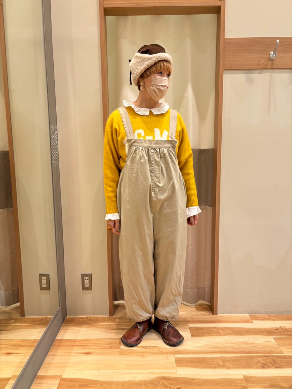 ホワイト系のシャツ/ブラウス、イエロー系のニット/セーター、ベージュ系のオールインワン・サロペットを着用したレディースの秋コーディネートの2枚目の写真