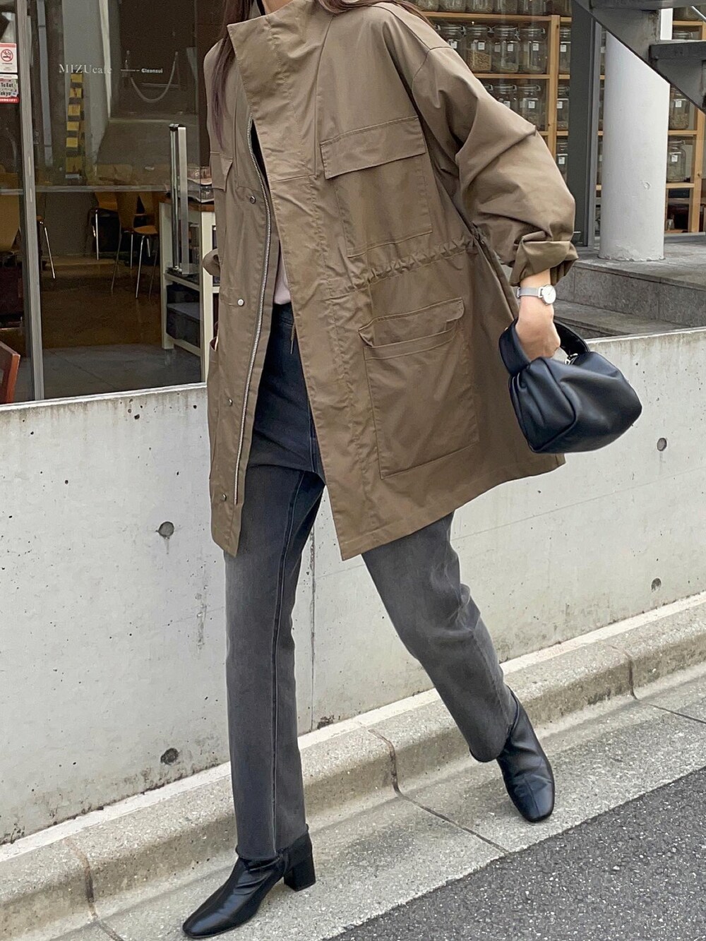 ブラウン系のシャツ/ブラウス、ブラック系のトートバッグ、グリーン系のミリタリージャケットを着用したレディースの秋コーディネートの3枚目の写真