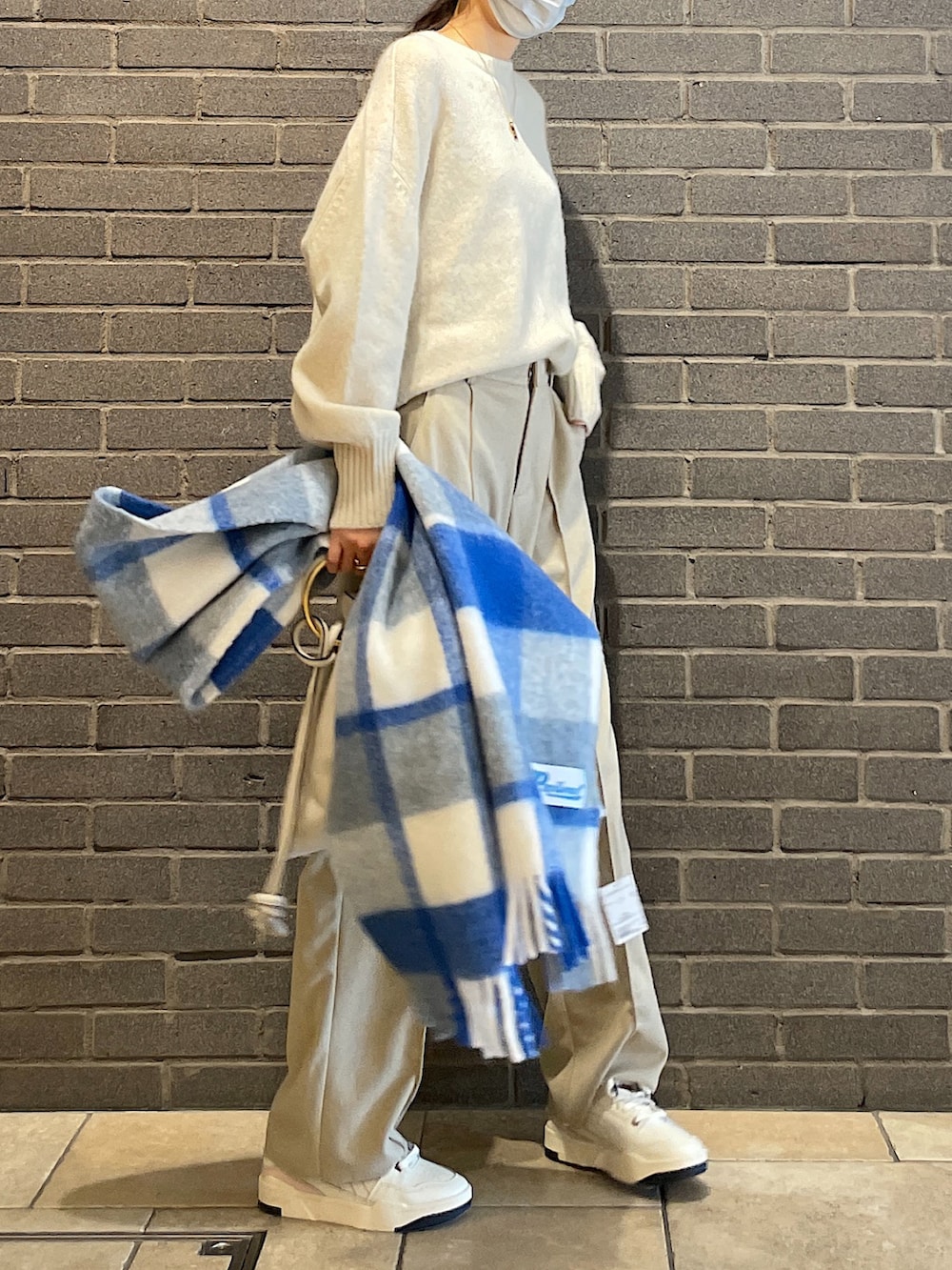 ベージュ系のニット/セーター、ベージュ系のスラックス、ホワイト系のトートバッグを着用したレディースの冬コーディネートの5枚目の写真
