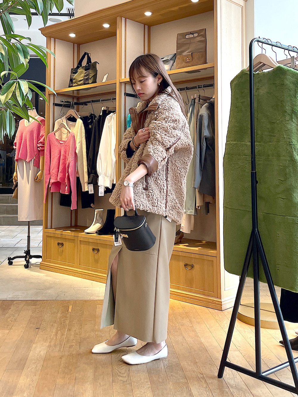 ベージュ系のブルゾン、ブルー系のニット/セーター、ベージュ系のスカートを着用したレディースの秋コーディネートの3枚目の写真