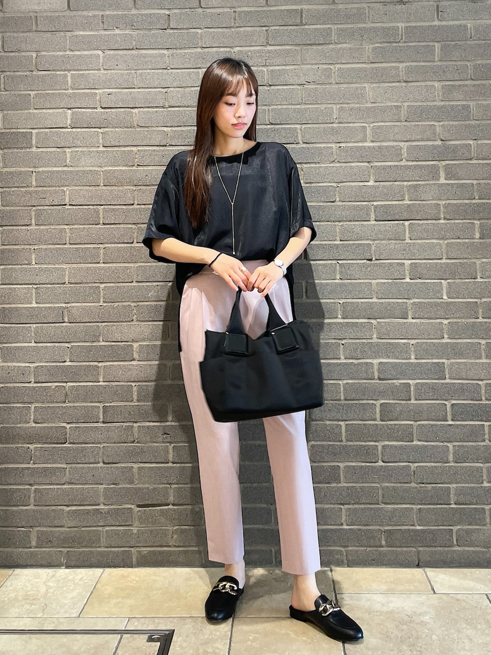 ブラック系のTシャツ/カットソー、ピンク系のスラックス、ブラック系のトートバッグを着用したレディースの夏コーディネートの3枚目の写真