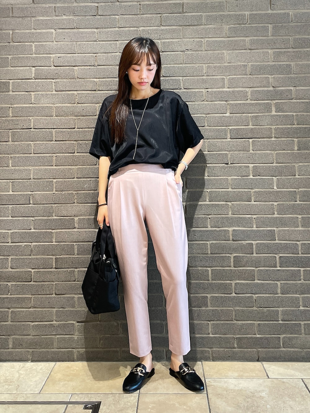 ブラック系のTシャツ/カットソー、ピンク系のスラックス、ブラック系のトートバッグを着用したレディースの夏コーディネートの2枚目の写真