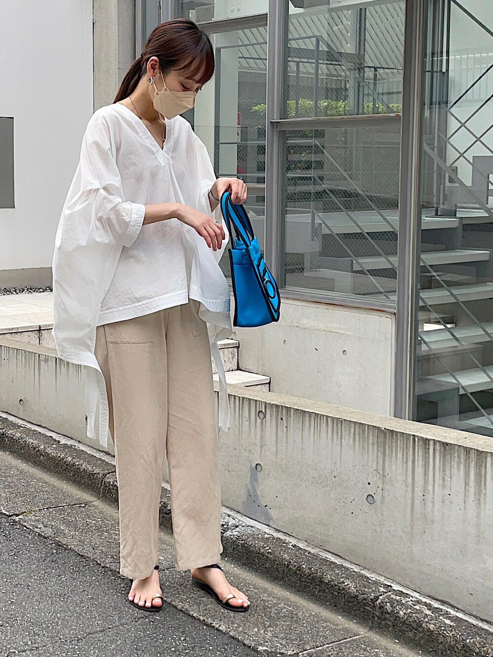 ホワイト系のシャツ/ブラウス、ベージュ系のその他パンツ、ブルー系のトートバッグを着用したレディースの夏コーディネートの2枚目の写真