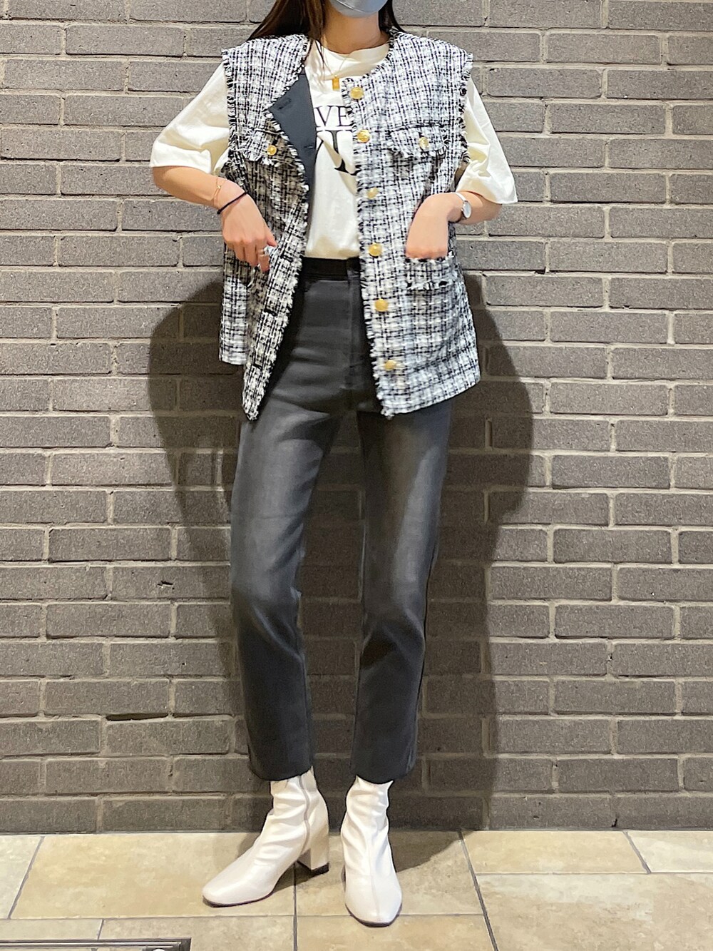 ブラック系のノーカラージャケット、ホワイト系のTシャツ/カットソー、グレー系のデニムパンツを着用したレディースの秋コーディネートの2枚目の写真