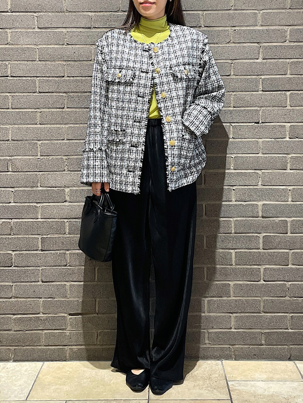 ブラック系のノーカラージャケット、ホワイト系のTシャツ/カットソー、グレー系のデニムパンツを着用したレディースの秋コーディネートの5枚目の写真