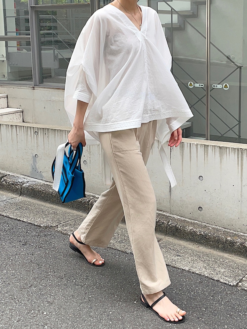 ホワイト系のシャツ/ブラウス、ベージュ系のその他パンツ、ブルー系のトートバッグを着用したレディースの夏コーディネートの3枚目の写真