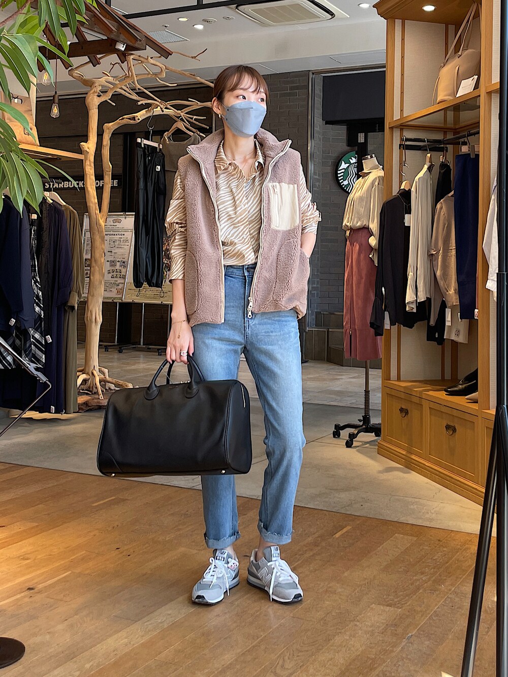 ベージュ系のその他アウター、ベージュ系のシャツ/ブラウス、ブルー系のデニムパンツを着用したレディースの秋コーディネートの2枚目の写真