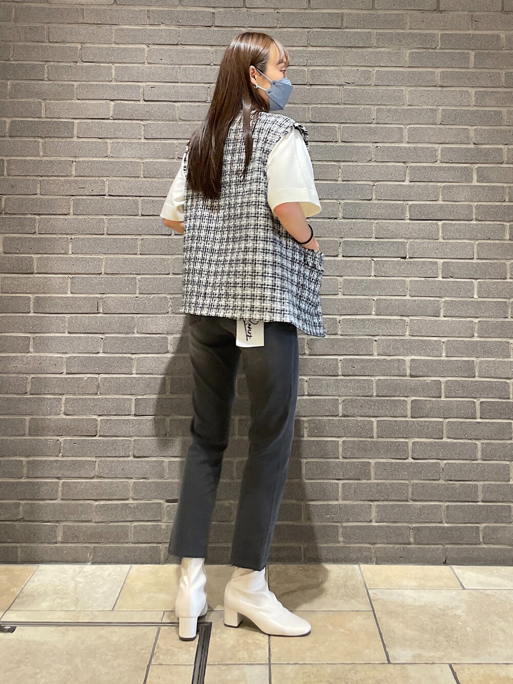 ブラック系のノーカラージャケット、ホワイト系のTシャツ/カットソー、グレー系のデニムパンツを着用したレディースの秋コーディネートの4枚目の写真