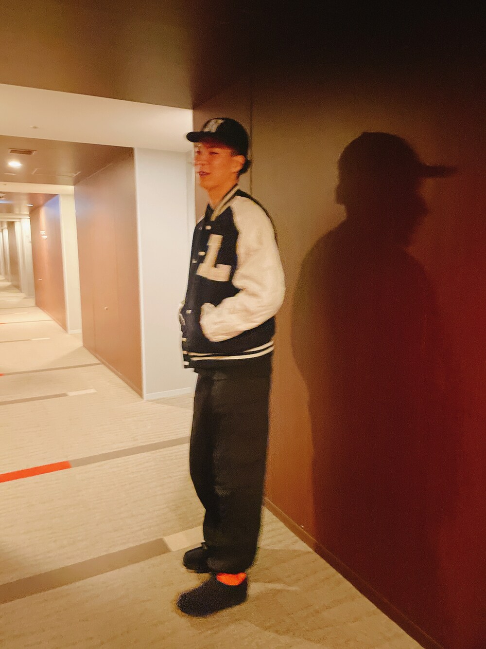 ブラック系のパンツ、ブラック系のシューズ、その他のスタジャンを着用したメンズの冬コーディネートの2枚目の写真