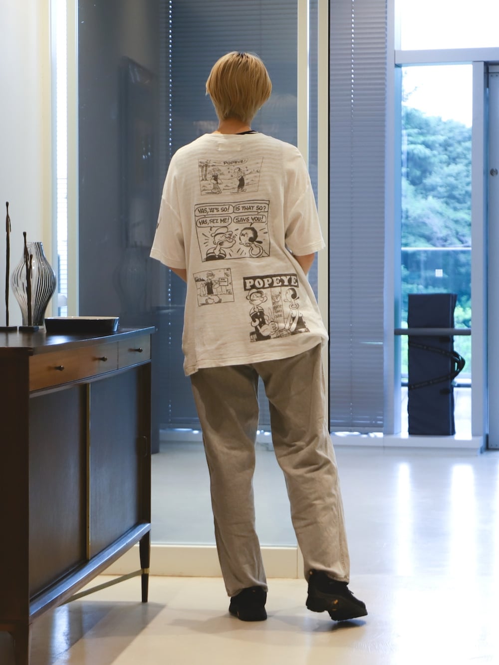 ブラック系のタンクトップ、グレー系のデニムパンツ、ブラック系のスニーカーを着用したレディースの夏コーディネートの2枚目の写真