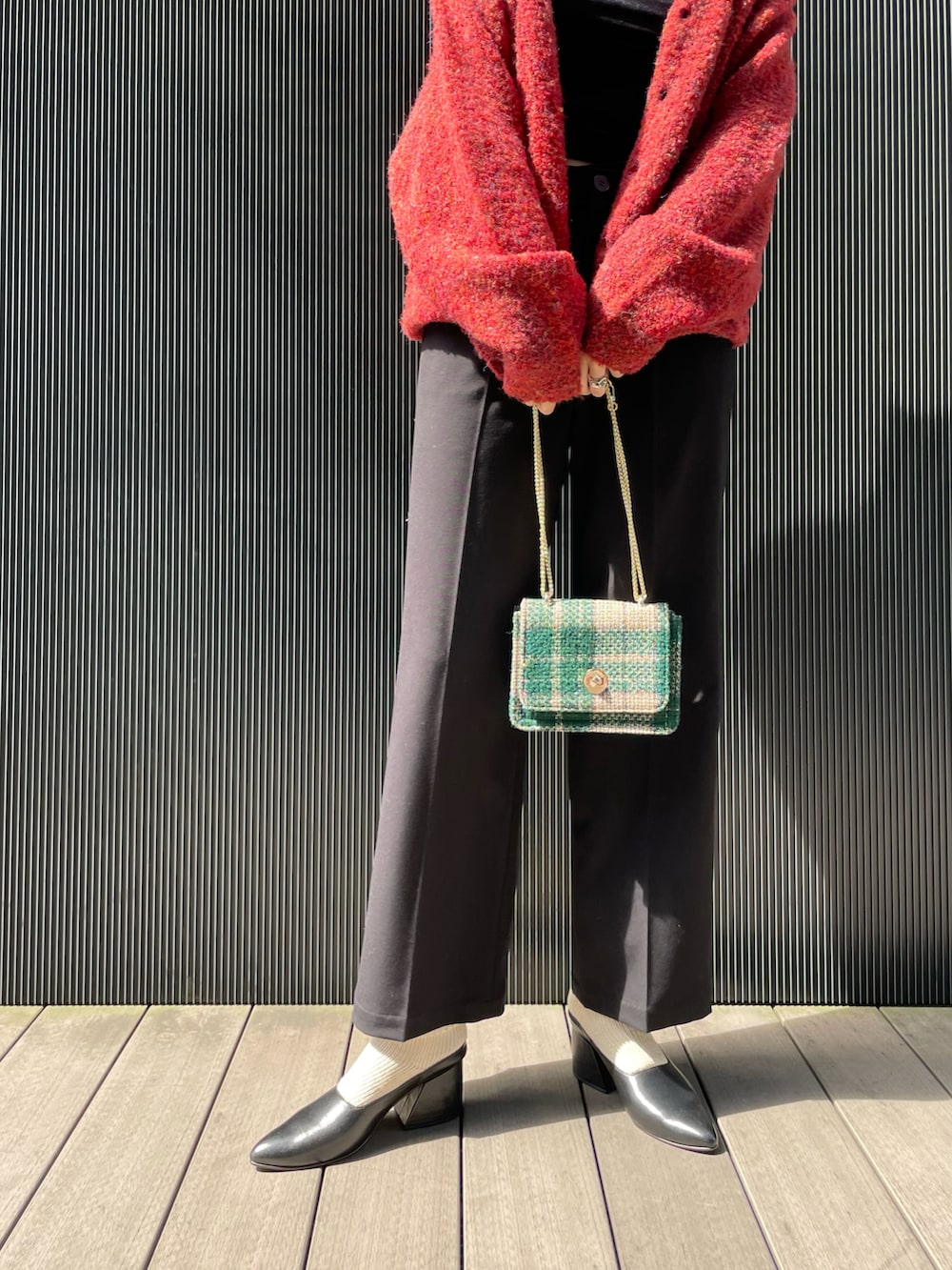 レッド系のカーディガン/ボレロ、ブラック系のキャミソール、ブラック系のその他パンツを着用したレディースの秋コーディネートの3枚目の写真