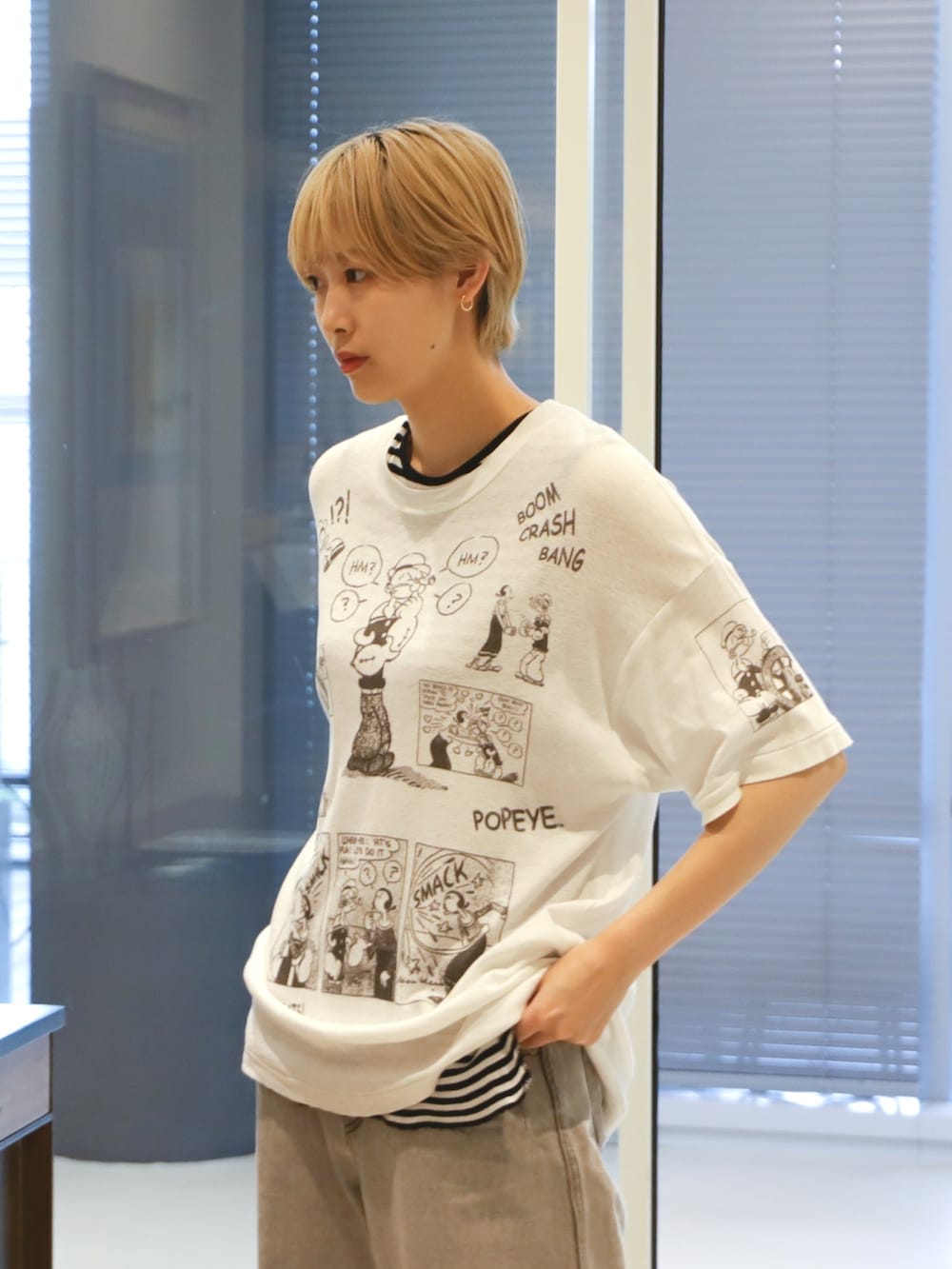 ブラック系のタンクトップ、グレー系のデニムパンツ、ブラック系のスニーカーを着用したレディースの夏コーディネートの3枚目の写真