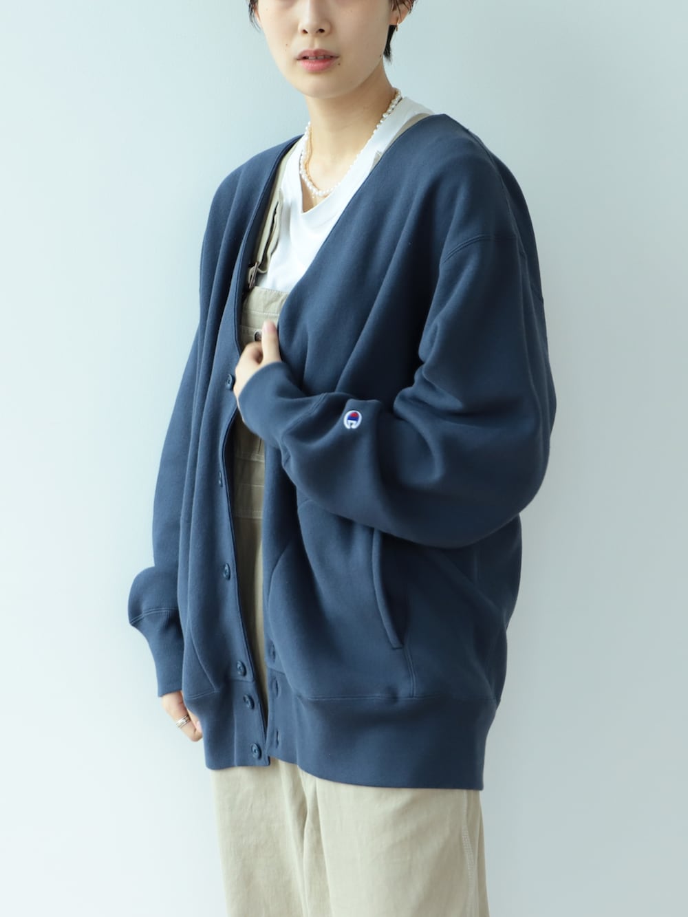 ベージュ系のサロペット/オーバーオール、ブルー系のスウェット、ブルー系のスニーカーを着用したレディースの秋コーディネートの3枚目の写真