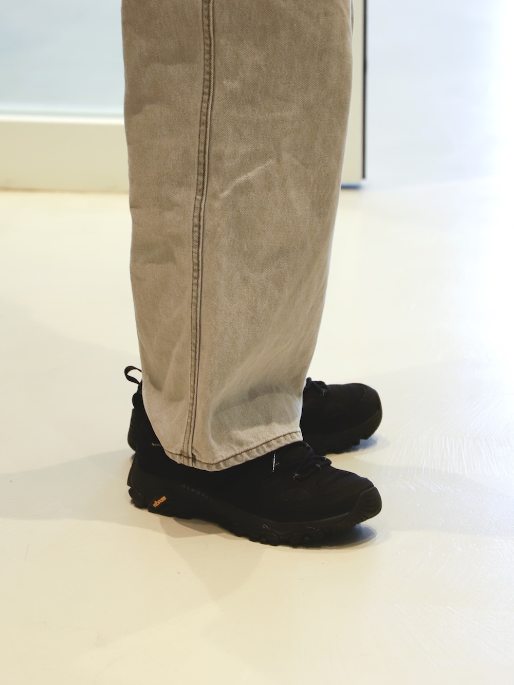 ブラック系のタンクトップ、グレー系のデニムパンツ、ブラック系のスニーカーを着用したレディースの夏コーディネートの4枚目の写真