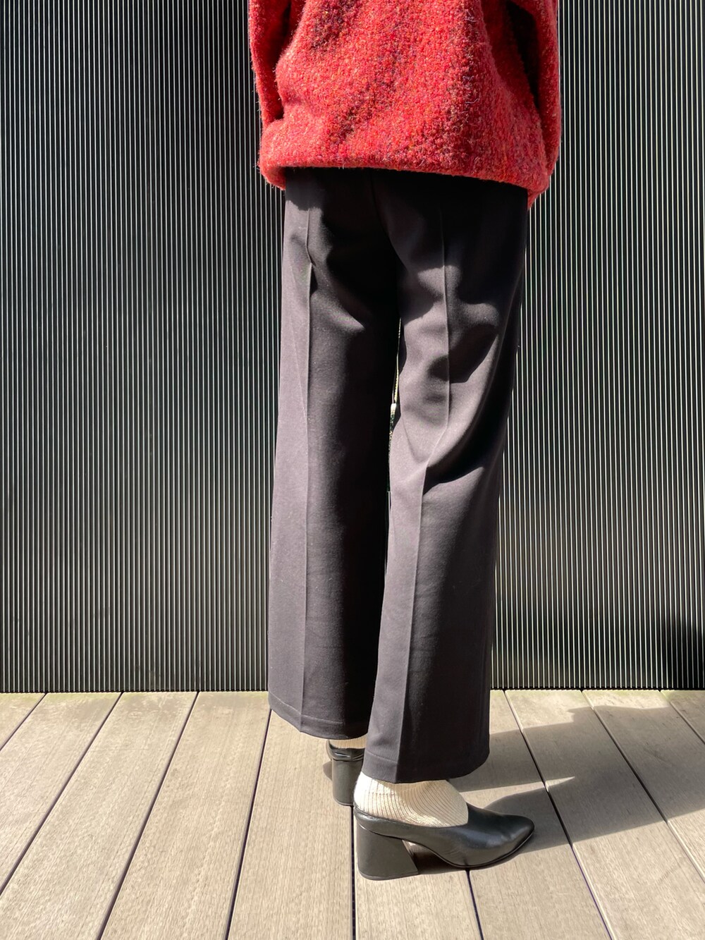 レッド系のカーディガン/ボレロ、ブラック系のキャミソール、ブラック系のその他パンツを着用したレディースの秋コーディネートの4枚目の写真