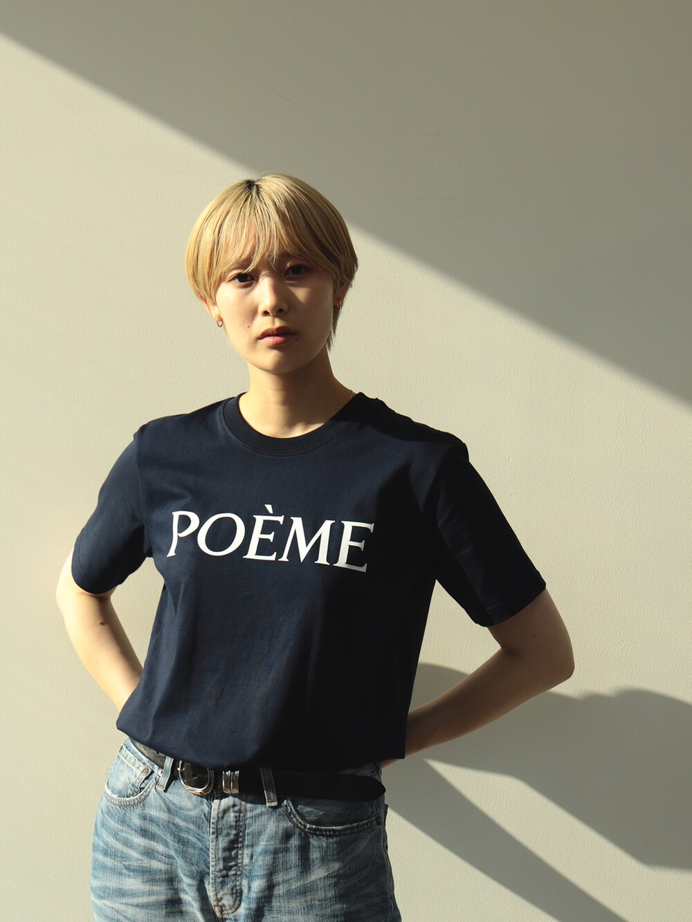 ブラック系のスニーカー、ブルー系のデニムパンツ、ブルー系のTシャツ/カットソーを着用したレディースの夏コーディネートの3枚目の写真