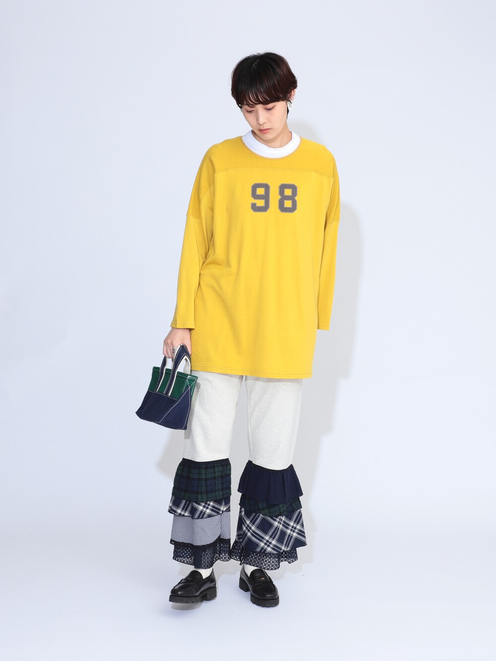 イエロー系のTシャツ/カットソー、グリーン系のトートバッグ、ブラック系のローファーを着用したレディースの夏コーディネートの2枚目の写真
